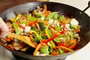 Asian-style stir-fry vegetables cooking in a wok - ghenghis grill augusta closed