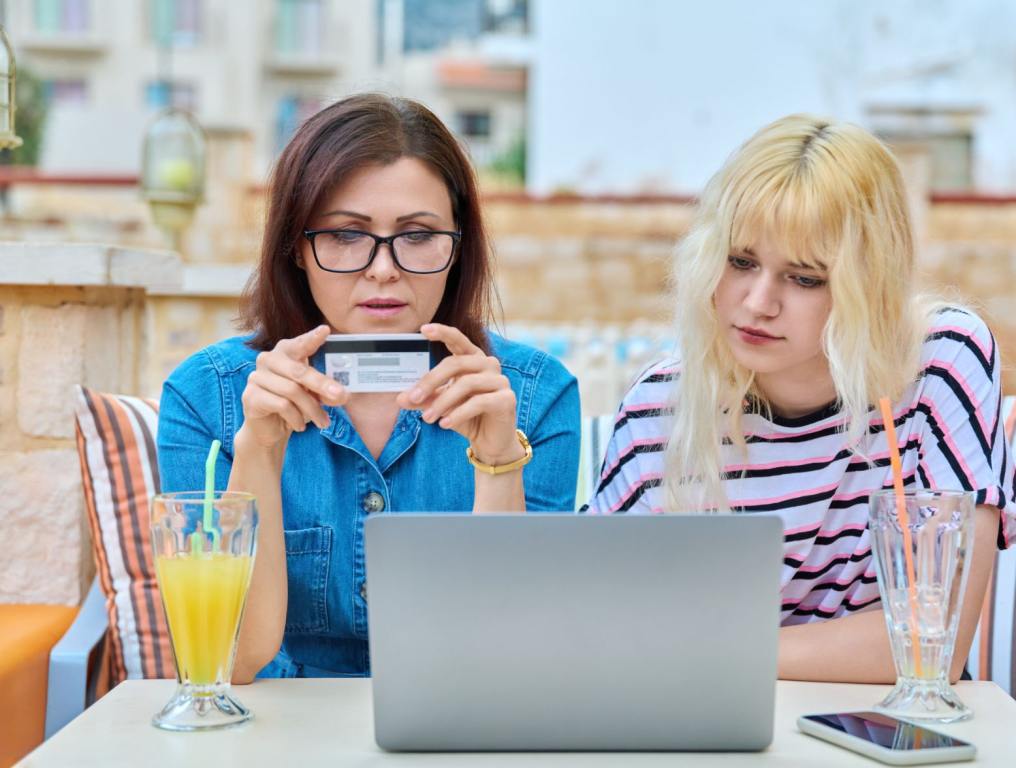 Two women looking at a credit card