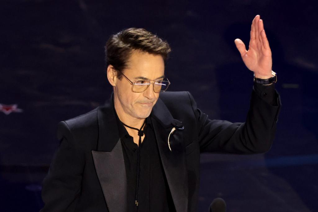 Robert Downey Jr. accepts the Best Actor in a Supporting Role for "Oppenheimer" onstage during the 96th Annual Academy Awards raising his arm up after apparently ignoring Ke Huy Quan.